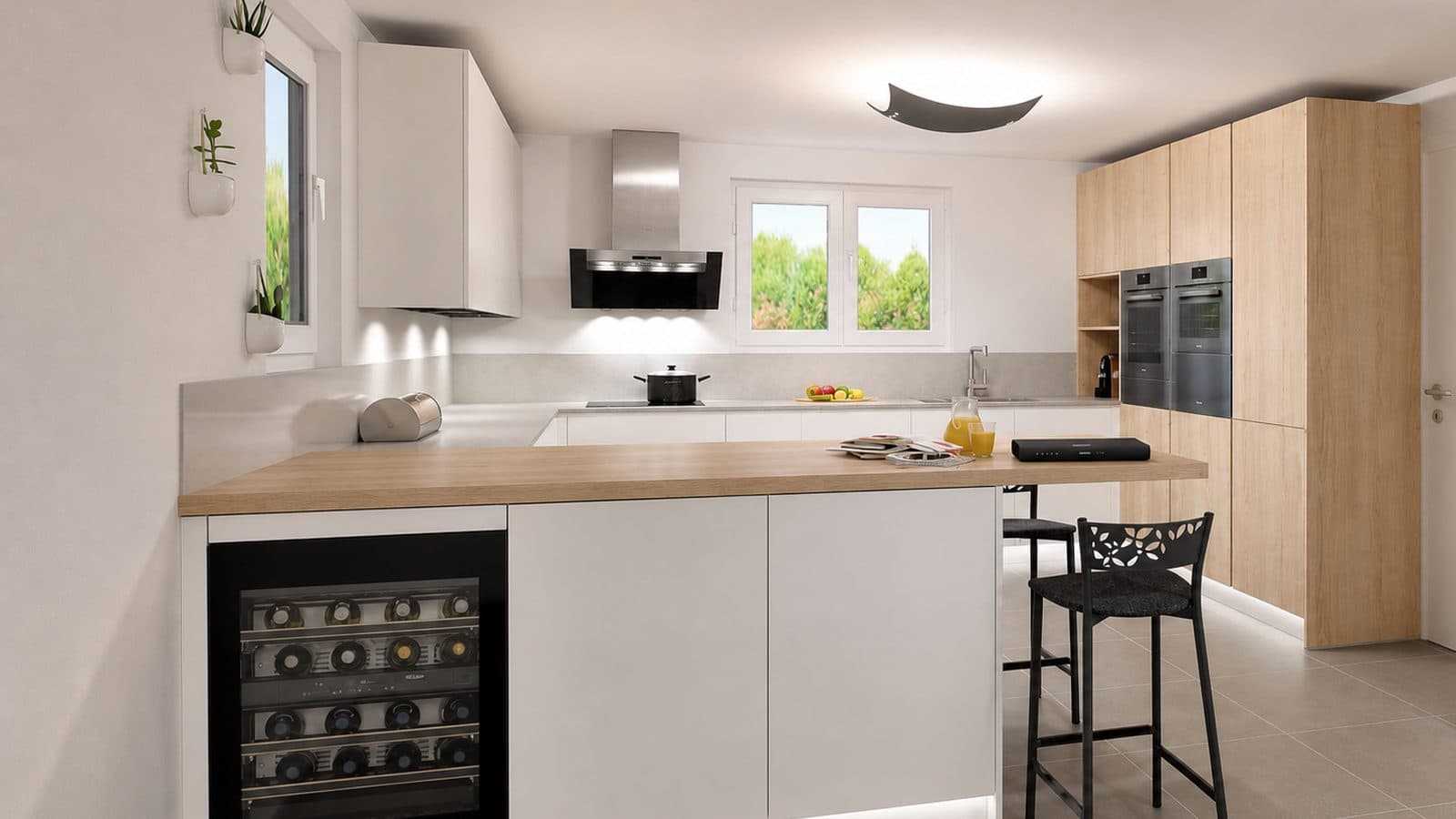 La même cuisine après rénovation : façades blanches sans poignée, plan de travail bois, colonnes en chêne clair et four encastré.