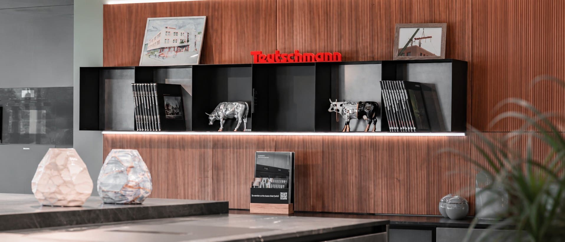 The signature wall of the Teutschmann showroom: sign, magazines and porcelain cows